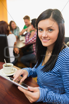 Female with coffee using tablet PC at  the coffee shop