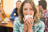 Close up of a smiling female having coffee at  coffee shop