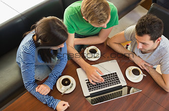 Students using laptop while having coffee at coffee shop