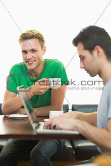 Students using laptop while having coffee at  coffee shop