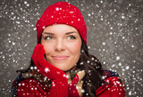 Mixed Race Woman Wearing Winter Hat and Gloves Enjoys Snowfall 
