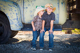 Two Young Boys Wearing Cowboy Hats Leaning Against Antique Truck