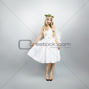 Young Woman in Angel Costume on Gray Background