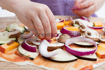 small hands preparing pizza