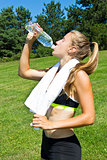 Athletic woman drinking water after a workout