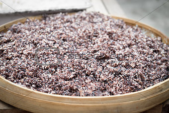 Steam black rice in big wooden plate