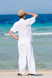 Man in a white suit against the sea