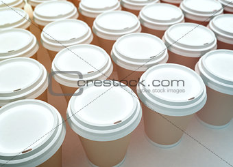 A row of paper coffee cups on a white background.