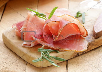 parma ham (jamon) sliced ​​on a wooden board