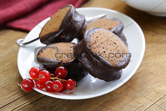 chocolate mini cakes decorated with currants on a white plate
