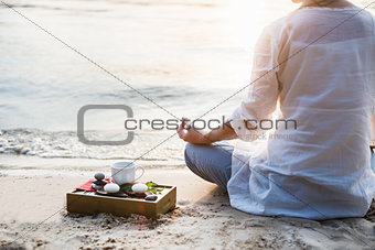 Woman meditating at the beach
