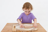 cute curly child rolling out dough