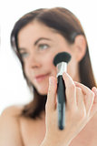 attractive woman in her forties applying makeup to her face
