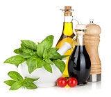 Olive oil and vinegar bottles with basil and tomatoes