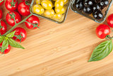 Olives, tomatoes and basil on cutting board
