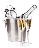 Champagne bottle in bucket, two glasses and alarm clock