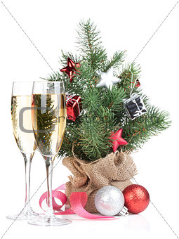 Small christmas tree with decor and two champagne glasses