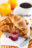 Breakfast with croissants, jam, cup of coffee and orange juice 