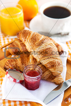 Breakfast with croissants, jam, cup of coffee and orange juice 