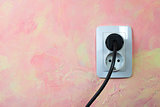 White socket and cable on pink wall. 