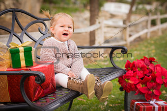 Young Toddler Child Sitting on Bench with Christmas Gifts Outsid