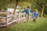 Happy Young Brother and Sister Running Outside