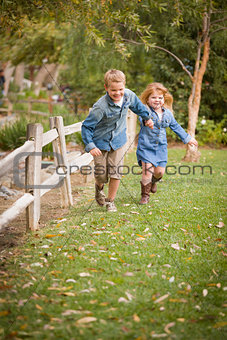 Happy Young Brother and Sister Running Outside