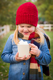Cute Young Girl Holding Cocoa Mug with Marsh Mallows Outside