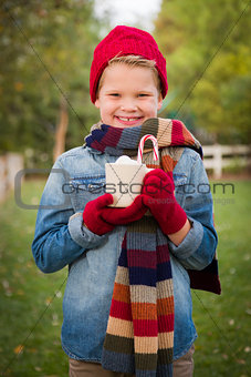 Young Boy in Warm Clothing Holding Hot Cocoa Mug Outside