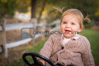 Young Toddler Laughing and Playing on Toy Tractor Outside