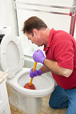 Man Using Plunger in Toilet