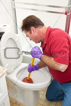 Man Using Plunger in Toilet