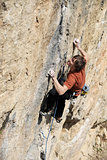 Rock climber struggling to make next movement