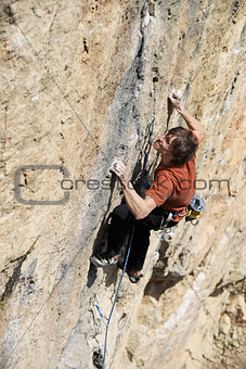 Rock climber struggling to make next movement