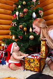 Cute baby boy and his mother against Christmas tree