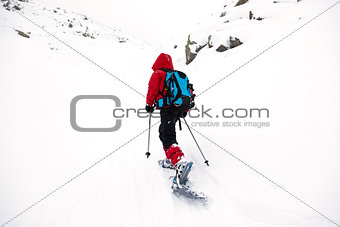 Boy hikes in mountain with snowshoe