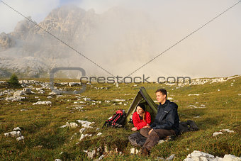 Young people camping in the mountains in fog