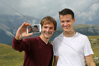 Friends taking pictures with a smartphone on holiday