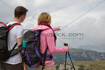 Young backpackers searching the destination in the mountains