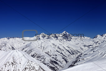 View on off-piste slope, winter snowy mountains and blue clear s