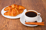Coffee cup with a croissant and fresh coffee beans