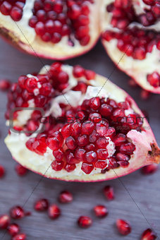 Pomegranate and pomegranate seeds on a wooden board
