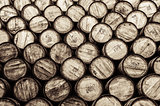 Detail monochrome view of stacked wine and whisky wooden barrels