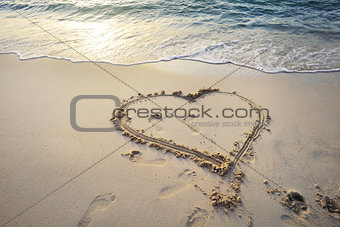 Heart written on sand.