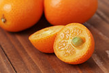 ripe kumquat fruits on wooden table
