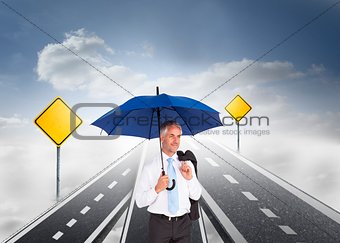 Mature businessman holding an umbrella