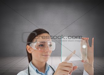Brunette doctor in protective glasses holding virtual screen