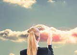 Blonde businesswoman pointing at cloud