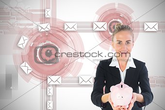Blonde businesswoman holding pink piggy bank