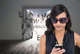 Concentrated brunette wearing sunglasses texting